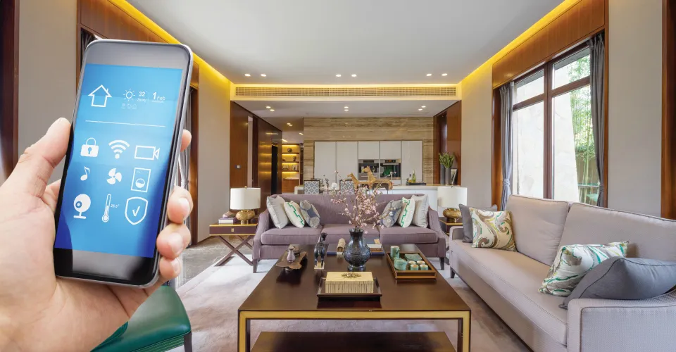 Hand holding phone with smart home app in luxury living room