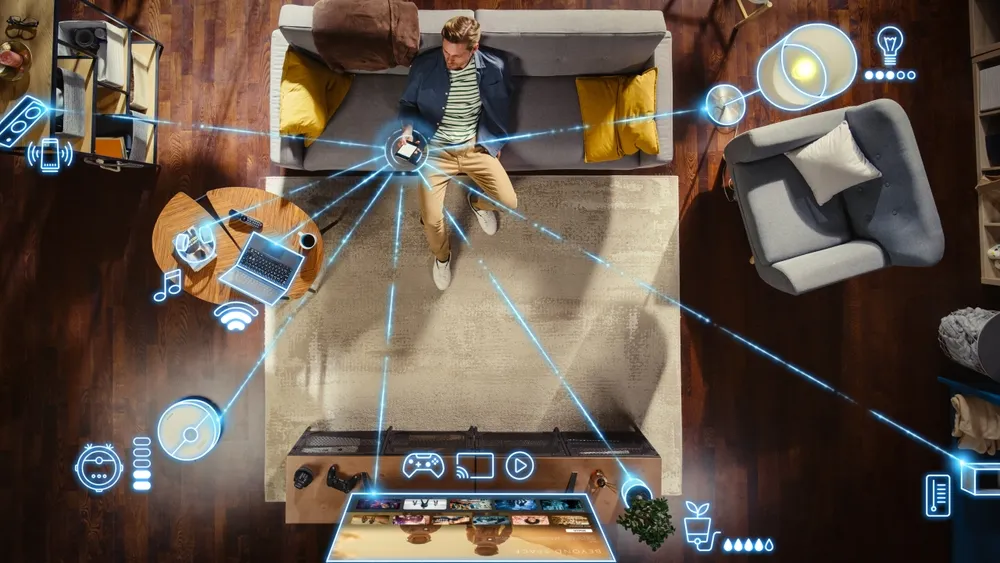 Overhead view of a man on a living room sofa using a phone, with glowing connection lines linking various smart home devices throughout the space